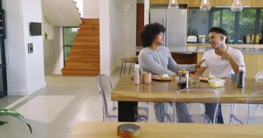 İki erkek arkadaş yumurta yiyor, kahvelerini yudumluyor ve gülüyorlar. Mutfak masasındaki ilk ısırıktan kaynaklanıyor. Arkadaşlık, gündelik, neşeli, yaşam tarzı, evcil, samimi, modern