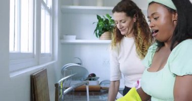 Yemekten sonra çeşitli bayan arkadaşlar bulaşıkları yıkıyor ve mutfak lavabosuna çay havlusuyla kurutuyorlar. Yurt içi, işbirliği, neşeli, rahat, ev halkı, paylaşılan, gündelik