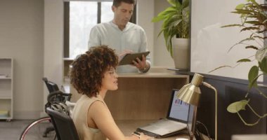 Çeşitli iş arkadaşları tablete yanıt veriyor, verileri tartışıyor, lambayı ayarlıyor ve notları masada yeniden düzenliyorlar. İşbirliği, modern, üretkenlik, ofis, çalışma alanı, takım çalışması, teknoloji