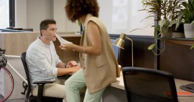 Çeşitli iş arkadaşları notlar yazıp dizüstü bilgisayarlarını kontrol ediyor, ofis masasında pasta grafiklerini değiş tokuş ediyorlar. İşbirliği, takım çalışması, analitik, iş, çalışma alanı, iletişim, modern