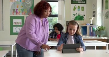 Sınıfta tabletli kız rehber öğretmen önemli bir şeye işaret ediyor, okulda. Eğitim, teknoloji, rehberlik, öğrenme, dijital, öğretim