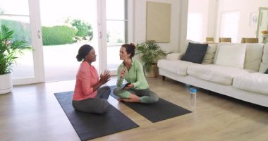 Çeşitli arkadaşlar oturma odasındaki yoga planlama rutininde yoga minderlerine beşlik çakarak tablet vuruyorlar. İşbirliği, bağlantı, sağlık, farkındalık, modern, yaşam tarzı, takım çalışması