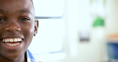 Okulda gülümseyen Afrikalı Amerikalı çocuk öğrenme sevincini ve coşkusunu dile getiriyor. Eğitim, çocukluk, mutluluk, öğrenim