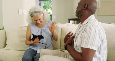 Üst düzey çift evde basınç testi için kelepçeleri hazırlıyor, sarılıyor ve ilaç kutusunu değiş tokuş ediyor. Sağlık, arkadaşlık, sağlık, şefkat, yaşlılık, rahatlık, aile