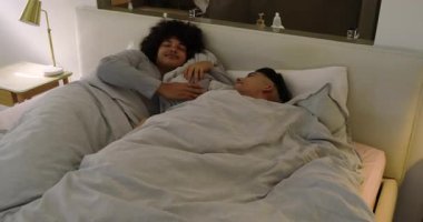 Çeşitli erkek partnerler, akıllı telefonu susturarak ve yatak odasındaki gülümsemeyi paylaşarak yumuşak alarma tepki veriyorlar. Samimiyet, sabah eğlencesi, rahatlama, birliktelik, rahatlık, sağIık, kırsallık.