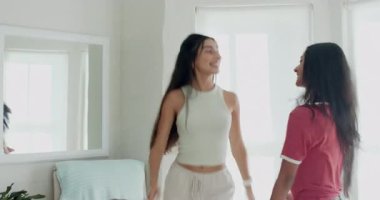 Hintli arkadaş kollarını kaldırdıktan sonra çeşitli bayan arkadaşlar yatak odasında yatakla dans ediyorlar. Arkadaşlık, dans, hareket, gündelik, yaşam tarzı, neşe, sağlık