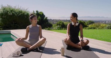 Çeşitli arkadaşlar havuz başında meditasyondan sonra kulaklıkları çıkarıyorlar. İçiyorlar ve akıllı telefondan sohbet ediyorlar. Rahatlama, dostluk, dinginlik, açık hava, refah, rahatlık, modern