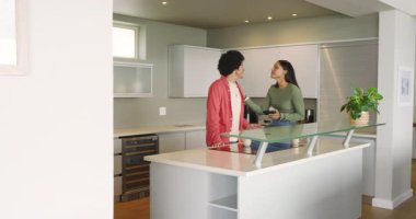 Çeşitli çiftler mutfakta sohbet ediyor sonra yiyecek paketlerini alıp boşaltmadan önce telefonları kaydırıyorlar. Yurt içi, yaşam tarzı, modern, rahat, samimi, sıcak, gündelik