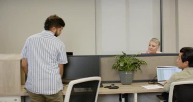 Hintli bir adam kabine giriyor, selam veriyor, masa yeşilliği için bitki yerleştiriyor ve bisikletle uzaklaşıyor. İşbirliği, çalışma alanı, yeşillik, kentsel, çevre dostu, modern, gündelik