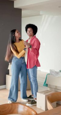 Dikey video: Çeşitli çiftler kutuları açıyor, kutuları açıyor ve duvar dekorasyon odasına asıyorlar. Paketleri açma, ev dekorasyonu, modernizm, yaşam tarzı, birliktelik, günlük yaşam tarzı, dikey video