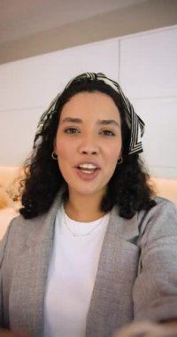 Dikey video: Parmak saklayan lensçi kadın ev mutfağını telefon panelleme sobasıyla gösteriyor ve el sallıyor. Ev, mutfak, modern, yaşam tarzı, gündelik, samimi, dikey video