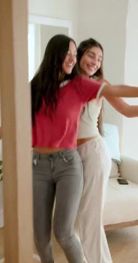 Çeşitli bayan arkadaşlar oturma odasında ayna aynasıyla akıllı telefonları kaydırdıktan sonra eğlenceli bir dans başlatıyorlar. Arkadaşlık, neşe, hareket, samimi, samimi, yaşam tarzı, dikey video