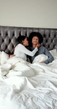 Çeşitli çiftler, kadın onu yatak odasından kalkması için dürtüyor, temiz çarşaflar hazırlıyor. Romantizm, samimiyet, rahatlık, uyum, ev, rahatlama, dikey video