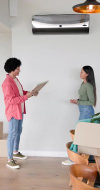 Dikey video: Çeşitli çift boş çerçeve gösteriyor, dekorasyon için evdeki beyaz duvara diziyorlar. Romantizm, iç mekan, minimalizm, ev, dekor, bağlantı, dikey video