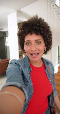 Dikey video: Kadın vlogger selamı, sonra eve gidip merdivenleri, mutfak adasını gösteriyor. İç mekan, modern, parlak, rahat, mimari, ev dekorasyonu, dikey video