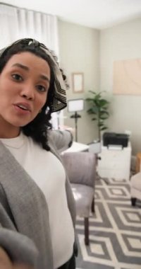 Dikey video: Kadın lensleri çıkarıyor ve gülümsemeden ve el sallamadan önce ev ofisini gösteriyor. Plazma, çalışma alanı, çağdaş yaşam tarzı, minimalizm, üretkenlik, dikey video