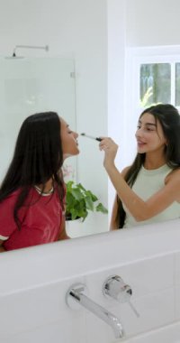 Çeşitli bayan arkadaşlar fırça alıp, banyo aynasında allık, pudra ve dudak boyası sürüyorlar. Dost canlısı, güzel, kozmetik, büyüleyici, canlı, kadınsı, dikey video