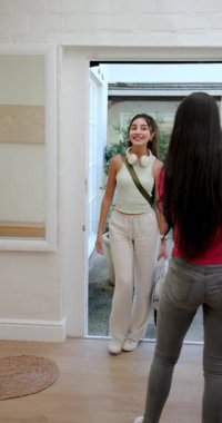 Dikey video: Çeşitli bayan arkadaşlar Hollanda kapısını açtıktan sonra antreyi kucaklıyor ve teftiş ediyorlar. Arkadaşlık, karşılama, konforlu, yaşam tarzı, iç mekan, gündelik, dikey video