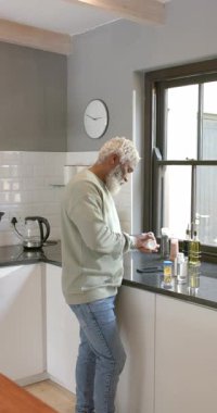 Dikey video: Güneş ışığı, Afrikalı Amerikalıları kavanoz etiketlerini okumaya, tezgahta yeniden mühürlemeye teşvik ediyor. Modern, minimalist, yaşam tarzı, iç mekan, sıcak, kendinden emin, dikey video