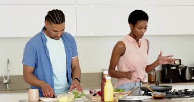 Adadaki bir çift tava hazırlarken domatesleri doğruyor. Aşçılık, mutfak, aşçılık, ev, takım çalışması, modern, sağlık