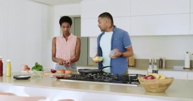 Mutfak adasında kırmızı soğana uzanan çeşitli çiftler yumurta hamuru pişiriyor ve hamburger yapıyorlar. Aşçılık, takım çalışması, modern, enerjik, yaşam tarzı, beslenme, yerli