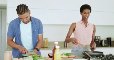 Çeşitli çiftler sebze dilimliyor, mutfak adasında tava karıştırıyor baharat tatma ve ayarlama yapıyor. Aşçılık, işbirliği, modern, ev tarzı, canlılık, tazelik, aşçılık