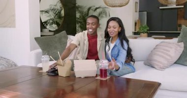 Oturma odasına giriyorlar, Afro-Amerikan çift kanepeye atlayıp uzaktan kumandayı gösteriyorlar. Yaşam tarzı, rahatlama, modern, rahat, eğlence, arkadaşlık, rahatlık