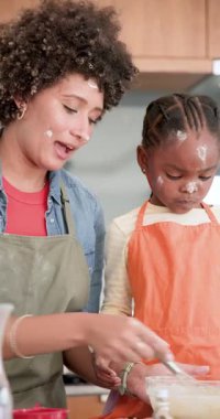 Çeşitli anne-kız selamlaşmaları, çırpma hamuru çırpmayı ve ev mutfağına süt dökmeyi öğretmeleri. Aile, eğitim, yetiştirme, bağlanma, yerli, yaratıcı, dikey video
