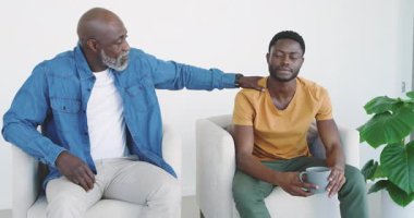Afro-Amerikalı bir baba evdeki oğlunun omzuna elini koyuyor, kupadan yudumlayarak oğlunu anlatıyor. Aile, akıl hocalığı, duygusal destek, bağlantı, sıcaklık, iletişim, dinlenme zamanı