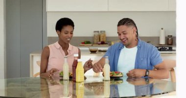 Mutfak masasındaki salatanın üzerine ketçap ve hardal döken farklı çiftler. Mutfak, yemek, günlük, keyiflilik, modern, yaşam tarzı, tazelik