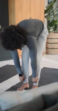 Çeşitli erkek arkadaşlar evdeki yoga minderlerinde ayakta dua pozu vererek tahtadan aşağı doğru süzülüyorlar. Spor, sağlık, esneklik, takım çalışması, modern, aktif, dikey video