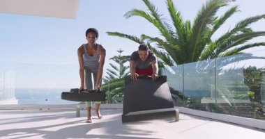 Çeşitli fitness partnerleri okyanus balkonunda yürüyor paspasları yerleştiriyor ve sonra ritmik nefesler soluyor. Sağlık, ahenk, dinginlik, açık hava, aktivite, rahatlama, farkındalık.