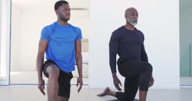 Eğitmenlikten sonra, Afrikalı Amerikalı erkekler avludaki yoga minderlerine diz çöküp kalçalarını esnetiyorlar. Spor, sağlık, esneklik, farkındalık, açık hava, huzur, uyum.