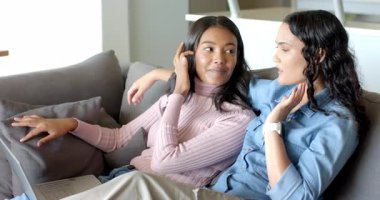 Modern oturma odasındaki kanepede oturan çeşitli bayan arkadaşlarla sohbet etmek, dizüstü bilgisayarlar ve akıllı seğirmeler. Gündelik, dostluk, iç mekan, modern, rahat, iletişim, konforlu