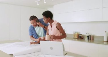 Akıllı telefonlar alıyoruz, Mutfak Adası 'nda çeşitli çiftler planları gözden geçiriyorlar ve dizüstü bilgisayarda yazı yazıyorlar. İşbirliği, beyin fırtınası, modern, yaşam tarzı, mimari, tasarım, yenilik