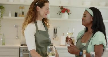 Çeşitli bayan arkadaşlar tost yapıyor, salatayı kasede karıştırıyor, ev mutfağında şarap bardaklarını tokuşturuyor. Aşçılık, arkadaşlık, işbirliği, organik, neşeli, enerjik, yerli