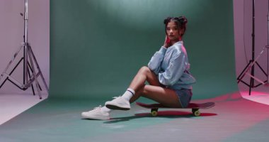 Asyalı bir kadın stüdyoda kaykayın üzerinde oturmaya başlıyor. Gövdesini değiştiriyor ve döndürüyor. Kentsel, dinamik, şık, atletik, çağdaş, enerjik, kavramsal