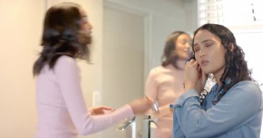 Lavabo aynasında, krom musluk ve perdelerle saç ve yüzük ayarlayan bir kadın. Kişisel bakım, bakım, zarafet, iç tasarım, yaşam tarzı, sükunet, hijyen