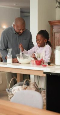 Dikey video: Afro-Amerikan baba tatma ve kızını mutfak adasında karıştırmaya teşvik etme. Aile, yemek pişirme, aile içi, gelenek, bağlanma, samimiyet, dikey video