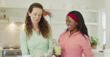 Smoothie 'yi döktükten sonra, çeşitli bayan arkadaşlar mutfakta tattıktan sonra selfie çekmeden önce telefona bakarlar. Sağlıklı, dostluk, yaşam tarzı, modern, canlı, sağlıklı, aşçı