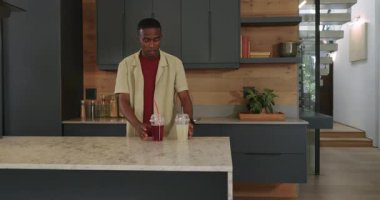 Afro-Amerikalı çift evlerinde televizyon izlerken mutfaktan bir şeyler içerek yemek için bakıyorlardı. Romantizm, rahatlama, samimiyet, çağdaş, samimi, yaşam tarzı, akşam yemeği