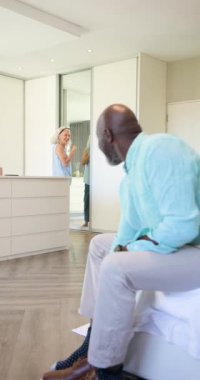 Dikey video: Son sınıf çifti dışarı çıkmadan önce elbise ayakkabıları giyer ve saçlarını şekillendirir. Romantik, arkadaşlık, zarafet, sıcaklık, yaşam tarzı, evcil, dikey video