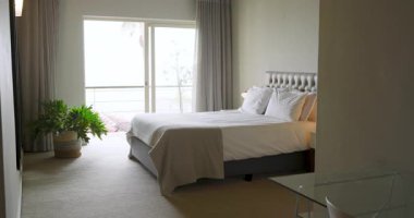 Yatak başlıklı yatak beyaz çarşaflar, bej rengi yatak odası, sürgülü kapının yanında bitki var. Lüks, huzur, rahatlama, çağdaş, konfor, iç mekan, konfor