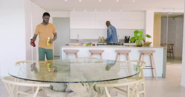 Afro-Amerikalı baba ve oğul yemek tabaklarından sonra cam masaya ketçap ve hardal taşıyorlar. Aile, bağ, beslenme, işçilik, birliktelik, modern, yaşam tarzı.