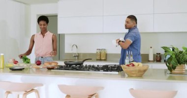 Mutfak adasında çeşitli çiftler tava çalkalayıp soğan doğruyor sonra da kahvaltıda yumurta pişiriyor. Aşçılık, işbirliği, aşçılık, modern, taze, ev işi, takım çalışması