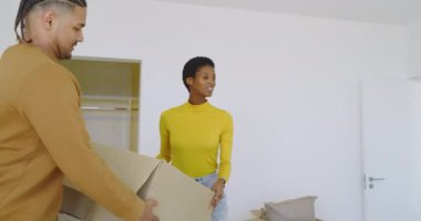 İspanyol bir adam ve Afro-Amerikan bir kadın yataktaki kazakları ayıklıyor. İşbirliği, rahatlık, minimalizm, yurtiçi, yaşam tarzı, şefkat, organizasyon