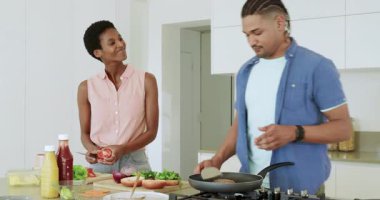 Mutfakta kahvaltıda yumurta pişirirken ve baharatlı yumurta pişirirken çeşitli çiftler güvertede soğan doğruyor. Aşçılık, mutfak, aşçılık, ev, takım çalışması, kahvaltı, yaşam tarzı