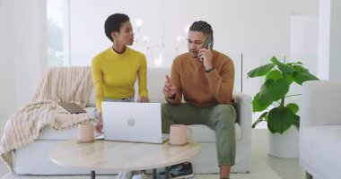 Kanepede oturan bir çift, kadın belgeleri incelerken ve dizüstü bilgisayarla çalışırken telefon görüşmesi yapıyor. Rahatlama, samimiyet, işbirliği, modern, samimi, iletişim, takım çalışması