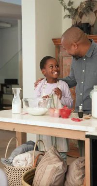 Dikey video: Afrika kökenli Amerikalı baba kızını mutfak adasında kek hamuru çırpmaya teşvik ediyor. Aile, akıl hocalığı, yerli, yaratıcı, sağduyulu, bağlayıcı, dikey video