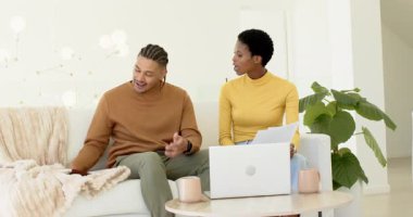 Karşılıklı bakışmalar çeşitli münazara kağıtları ve dizüstü bilgisayarlar, evdeki projeleri çözmek. İşbirliği, tartışma, takım çalışması, bağlantı, modern, samimi, iletişim